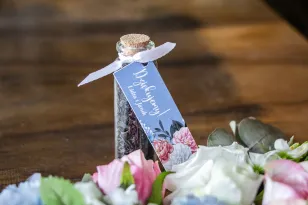 Podziękowania dla Gości w postaci buteleczek z herbatą. Przywieszka w kolorze „dusty blue”