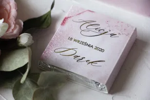 Podziękowanie dla gości weselnych w postaci mlecznej czekoladki. Marmurkowa, złocona owijka w odcieniu pastelowego różu