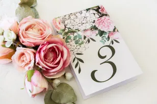 Nummern von Hochzeitstischen mit einem Aufdruck aus pastellfarbenen Rosen und weißen Hortensien mit grünen Zweigen