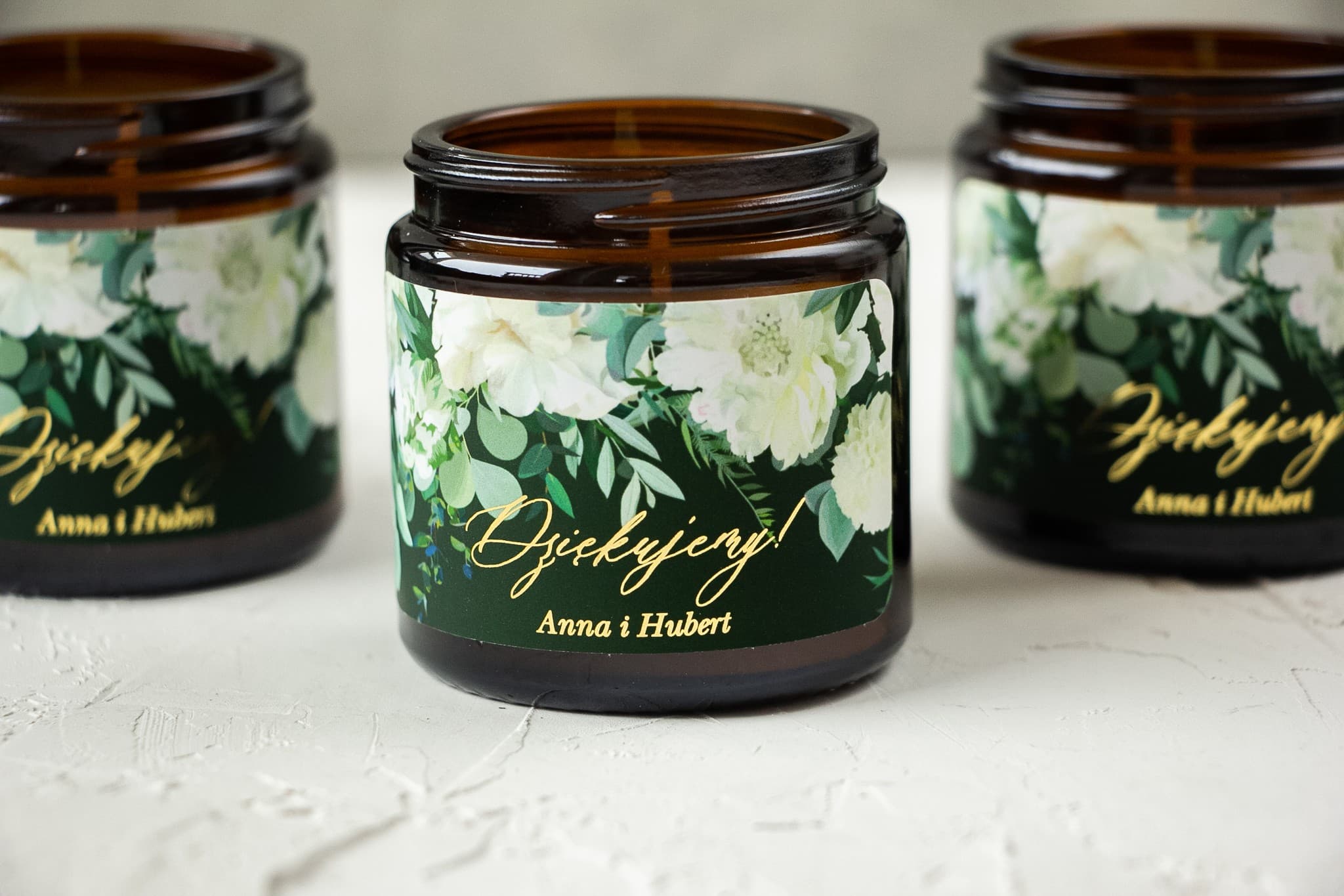 Détail de l'étiquette dorée sur bougie de mariage vert bouteille