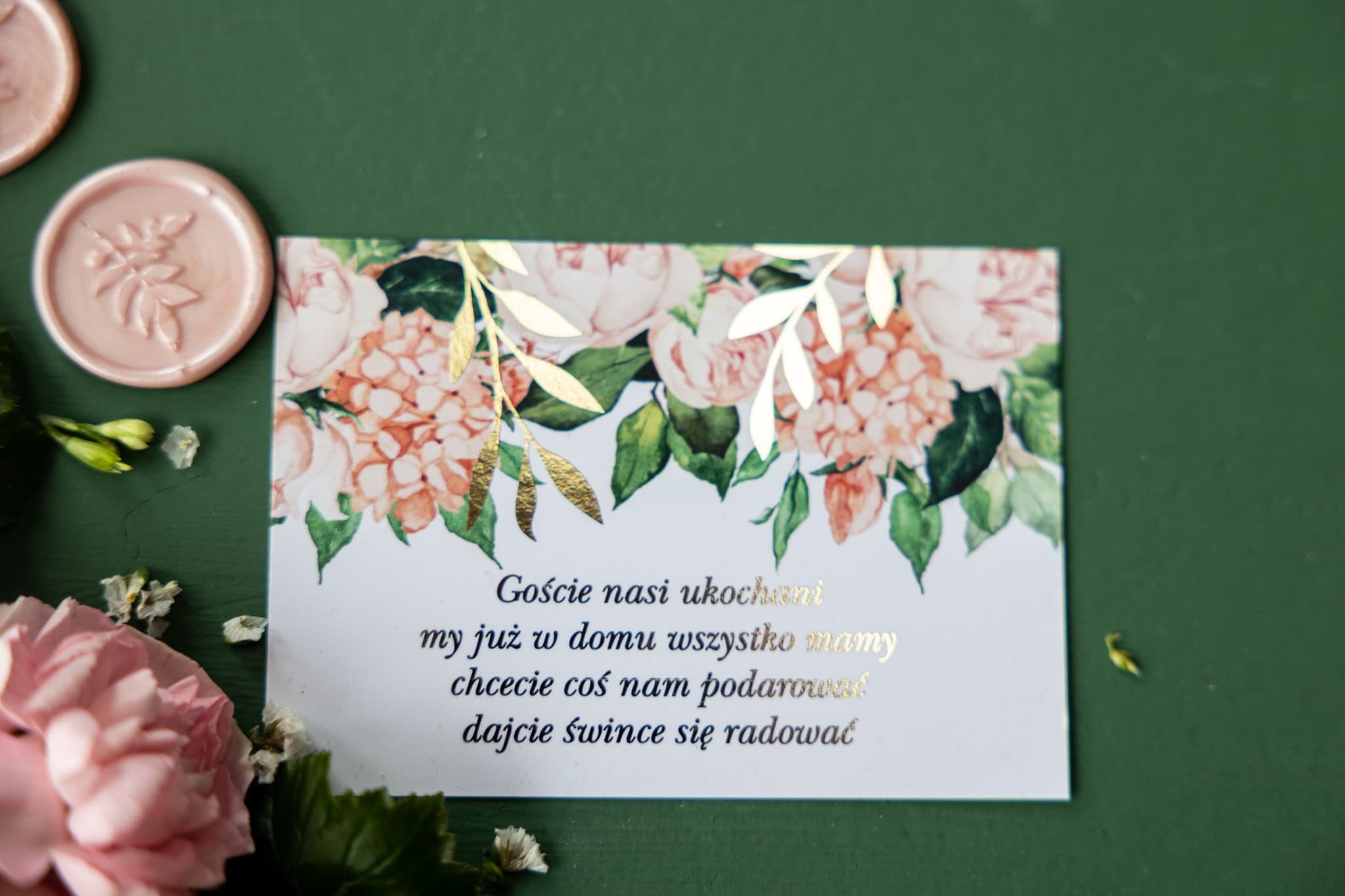 Carton d'invitation pastel avec branches dorées, pivoines roses et hortensias, texte doré