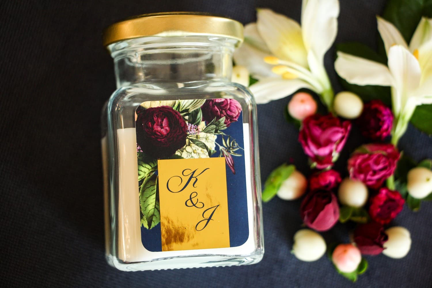 Duftkerzen Gastgeschenke Hochzeit im Glamour-Stil. Goldfoliertes Etikett mit Blumenstrauß