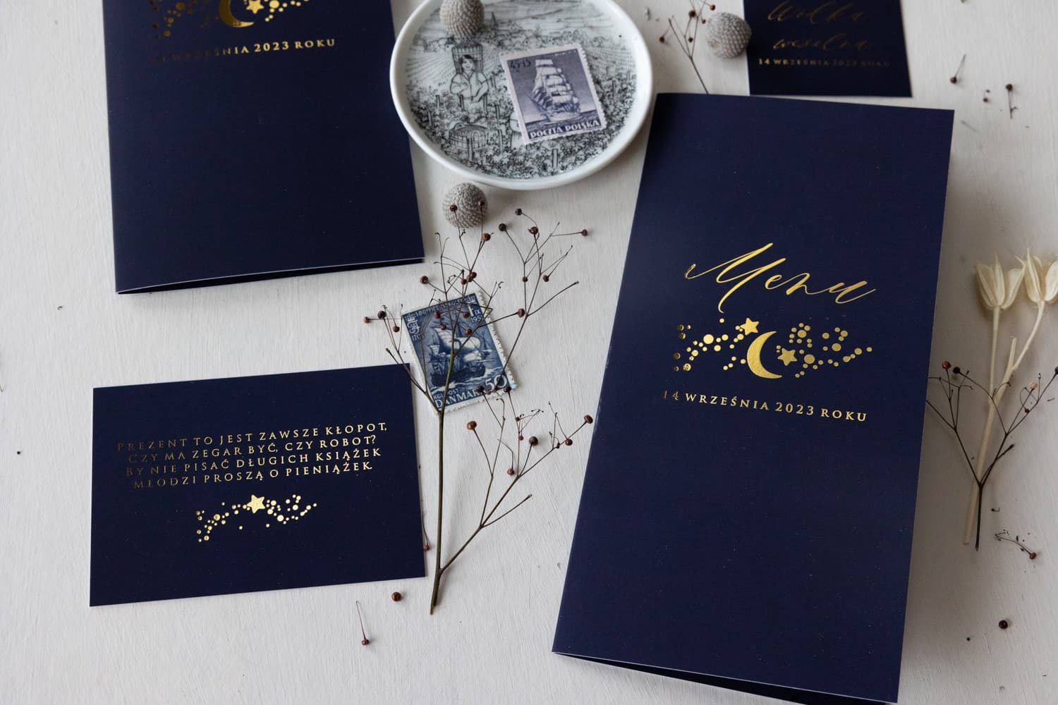 Elegant Wedding Table Menu with gold celestial pattern on navy blue paper.