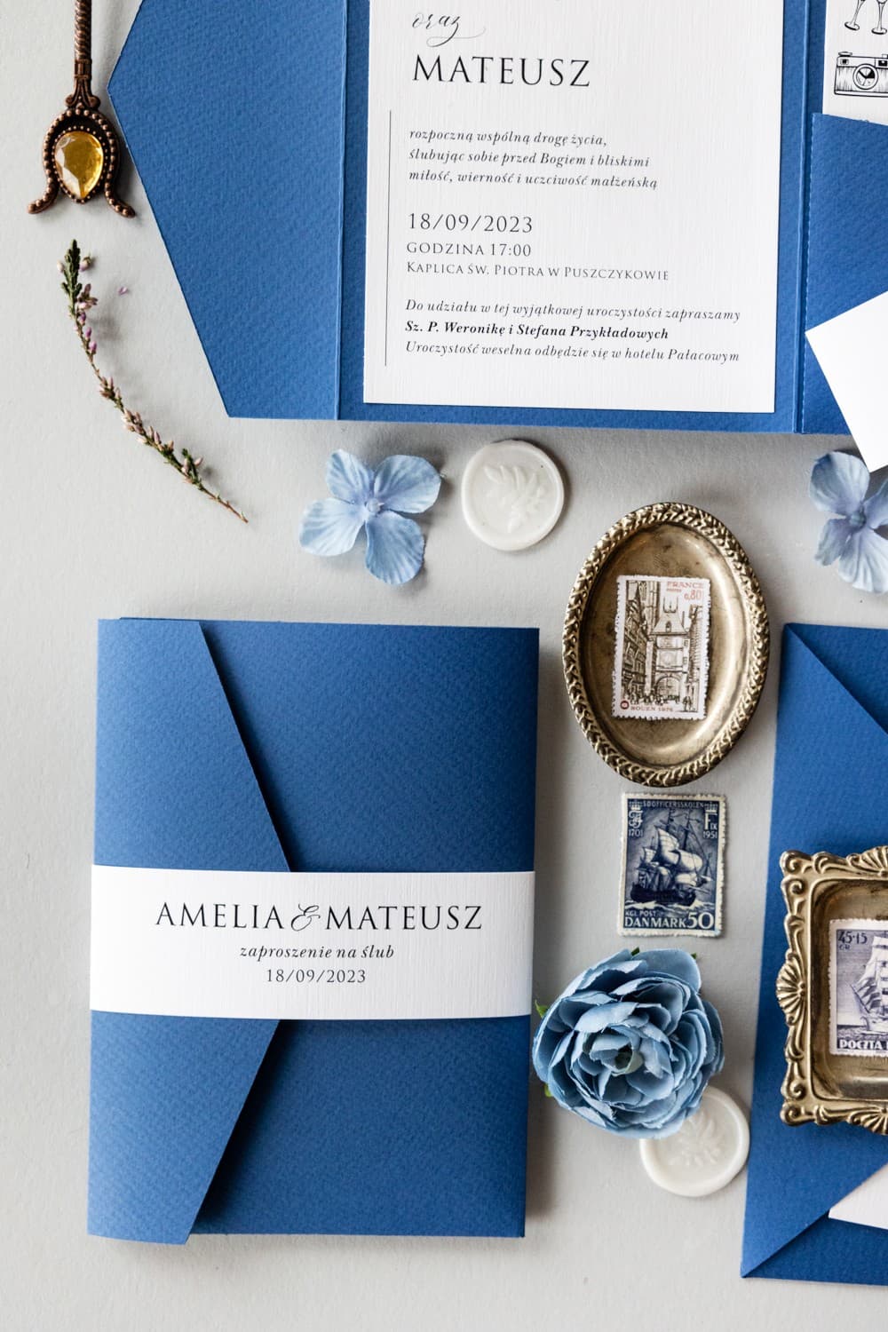 Invitaciones de boda azules en estuche con bolsillo para tarjeta y faja de Amelia-Wedding.pl