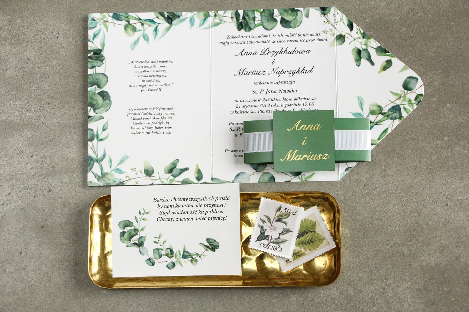Detalle de invitación de boda con ramas de eucalipto y acabado dorado