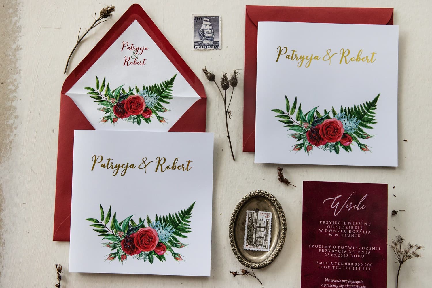 Detalle de invitación de boda con estampado dorado y flores violetas