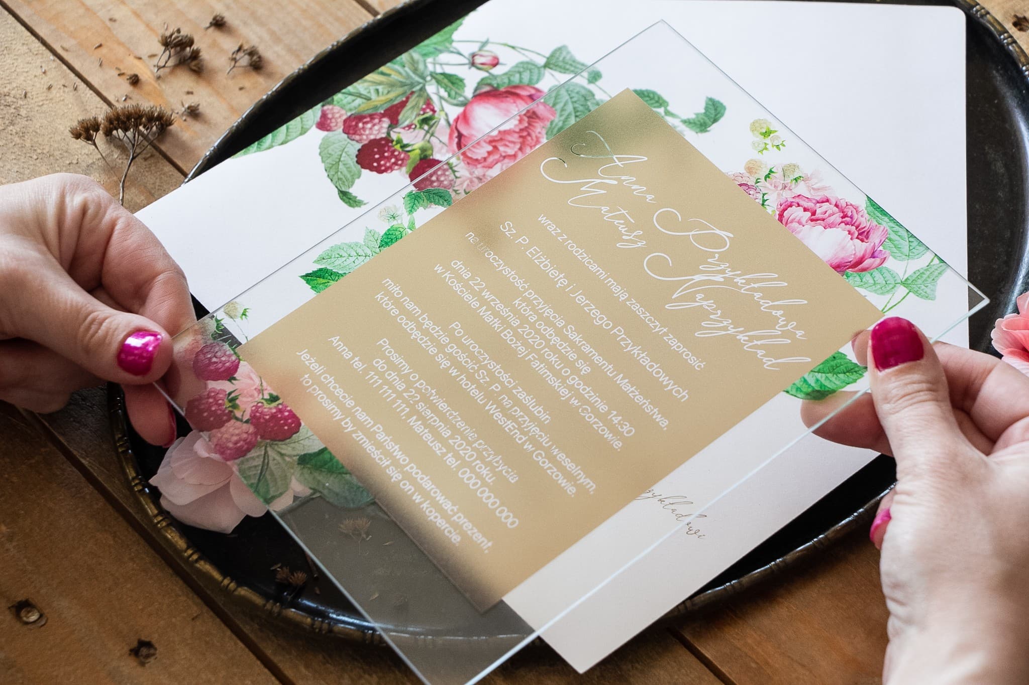 Invitaciones de boda en vidrio con peonías y frambuesas en un entorno de color crema delicado