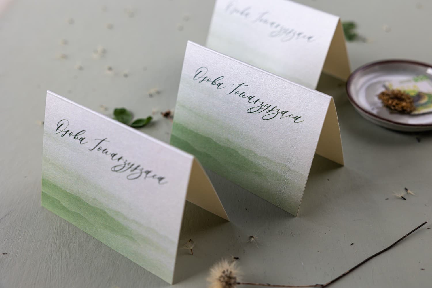 Tarjetas de mesa para invitados con diseño de hojas verdes y papel perlado