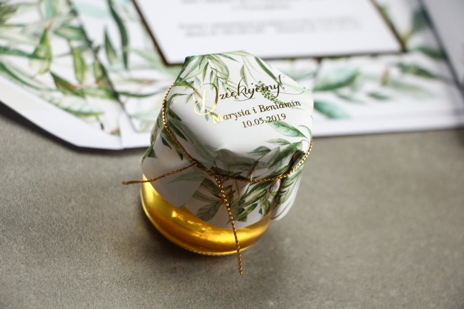 Vasetto di miele - dolce bomboniera per ospiti nuziali. Cappuccio con scritte dorate e motivo botanico greenery