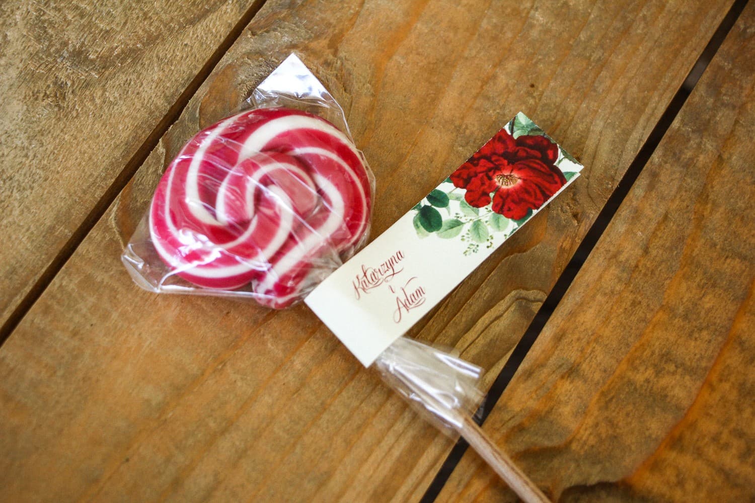 Sucettes - cadeaux d'invités de mariage. Étiquette avec rose de Chine rouge et branches vertes