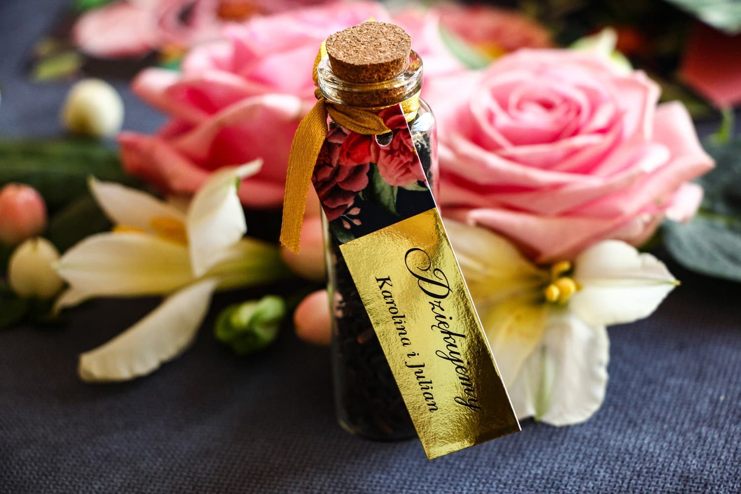 Gastgeschenke in Form von Teeglas-Fläschchen. Goldener Anhänger mit rosa Pfingstrosen und Rosen