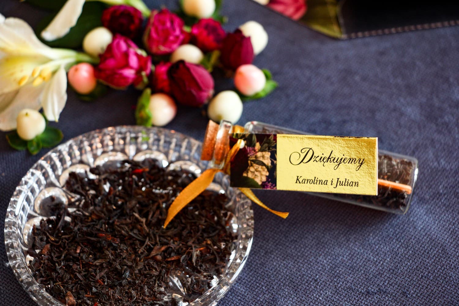 Gastgeschenke Hochzeit Tee im Glasfläschchen. Goldener Anhänger mit burgunder- und rosafarbenem Blumenstrauß