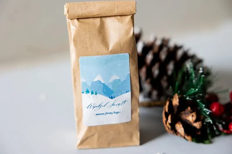 Close-up of a corporate Christmas tea label with winter landscape graphics and space for a client logo.