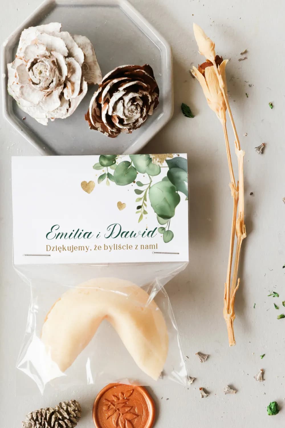 Green and gold wedding favour featuring a crispy fortune cookie with botanical label