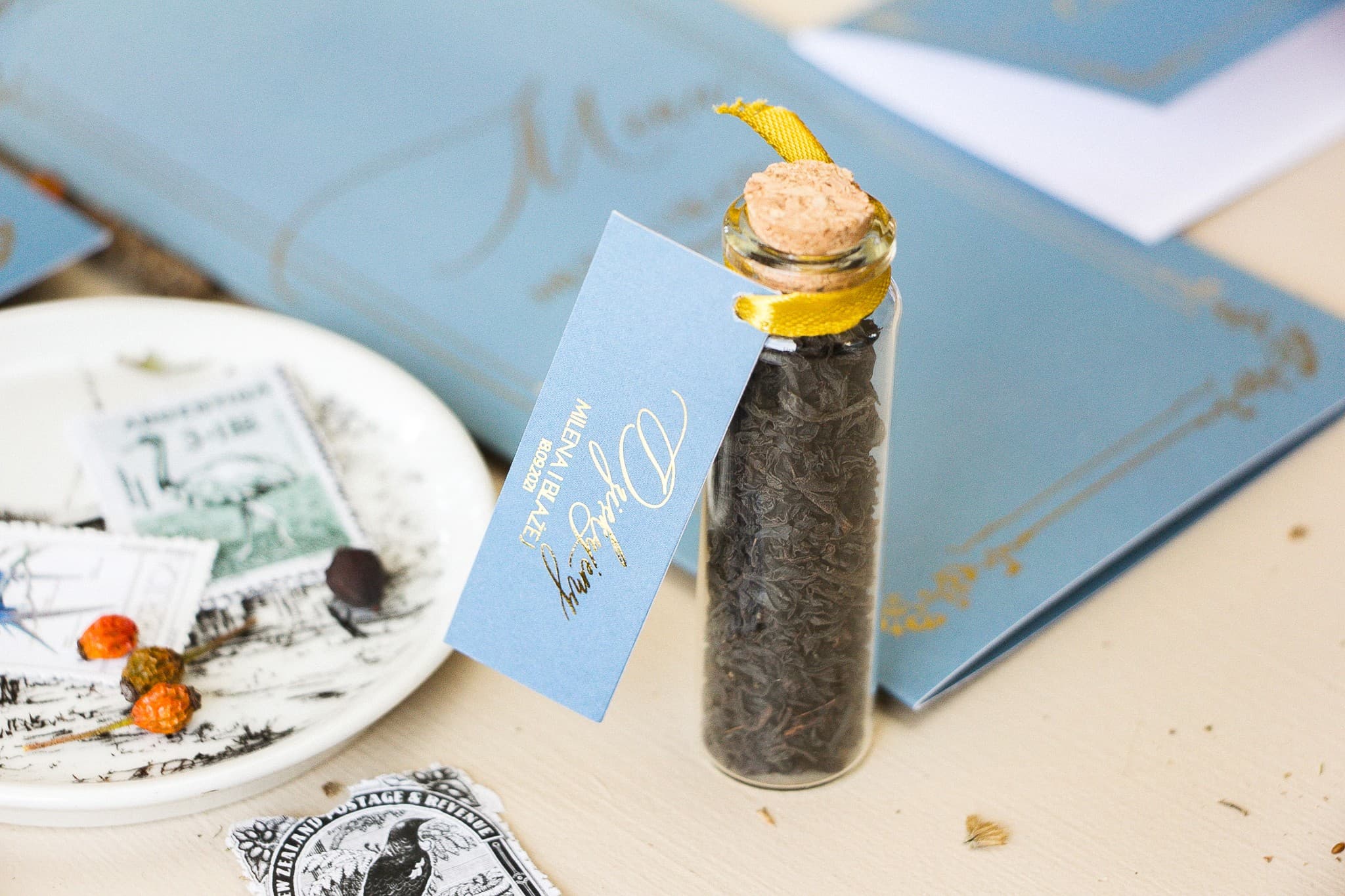 Regalos para invitados: botellitas de té con etiqueta estilo Glamour en color dusty blue