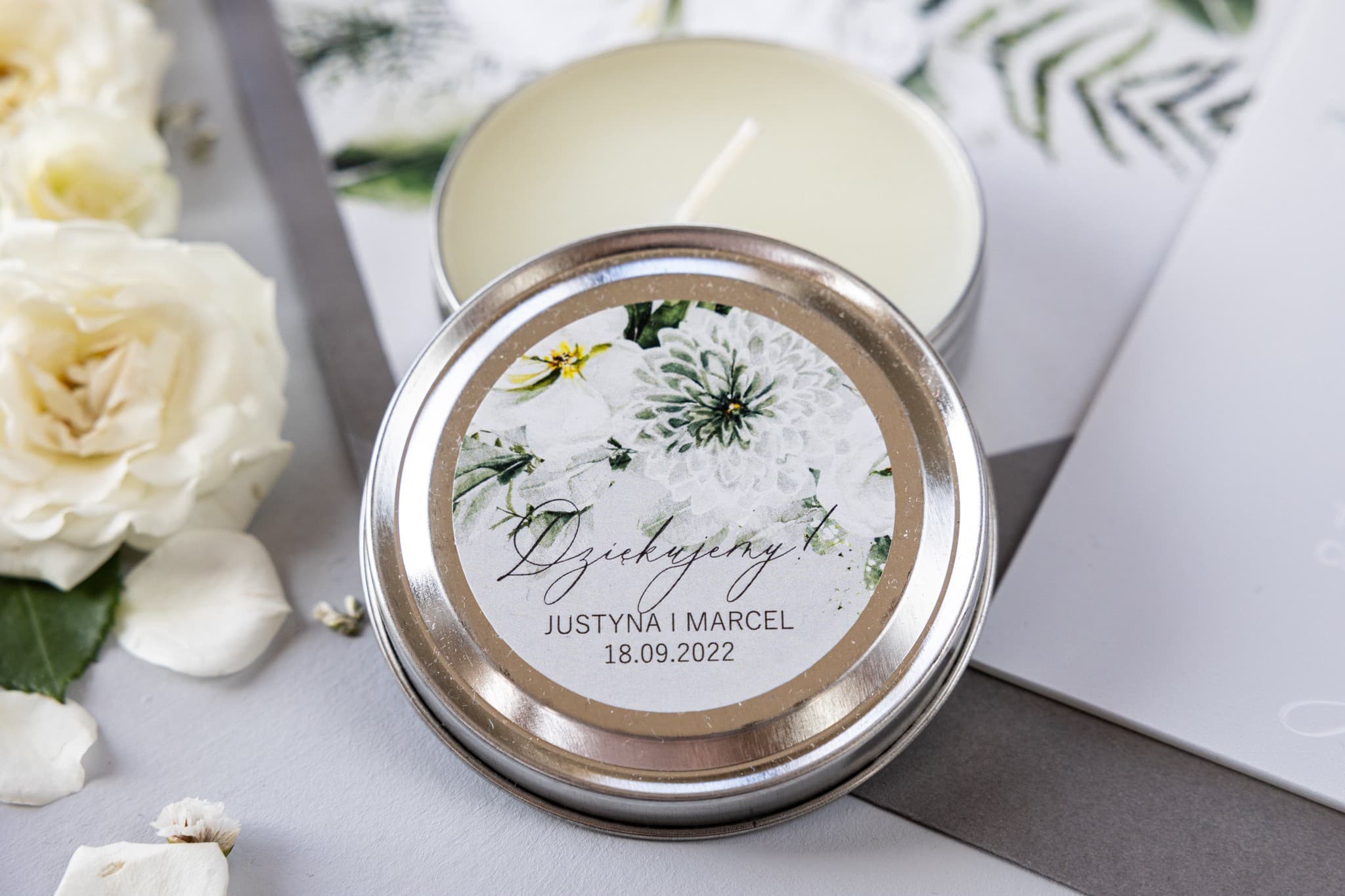 Candela in lattina con aster Candele nuziali rotonde come bomboniere per ospiti. Etichetta con aster e fiori bianchi