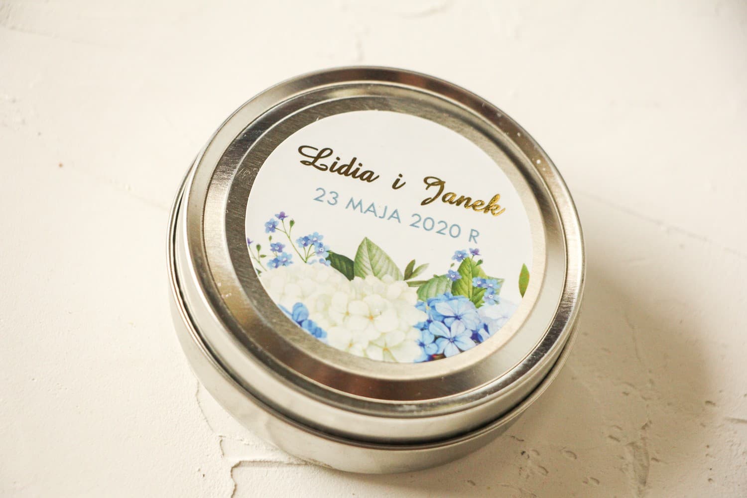 Candele tonde nuziali - ringraziamenti per gli ospiti del matrimonio. Etichetta con dorature e ortensia blu e bianca