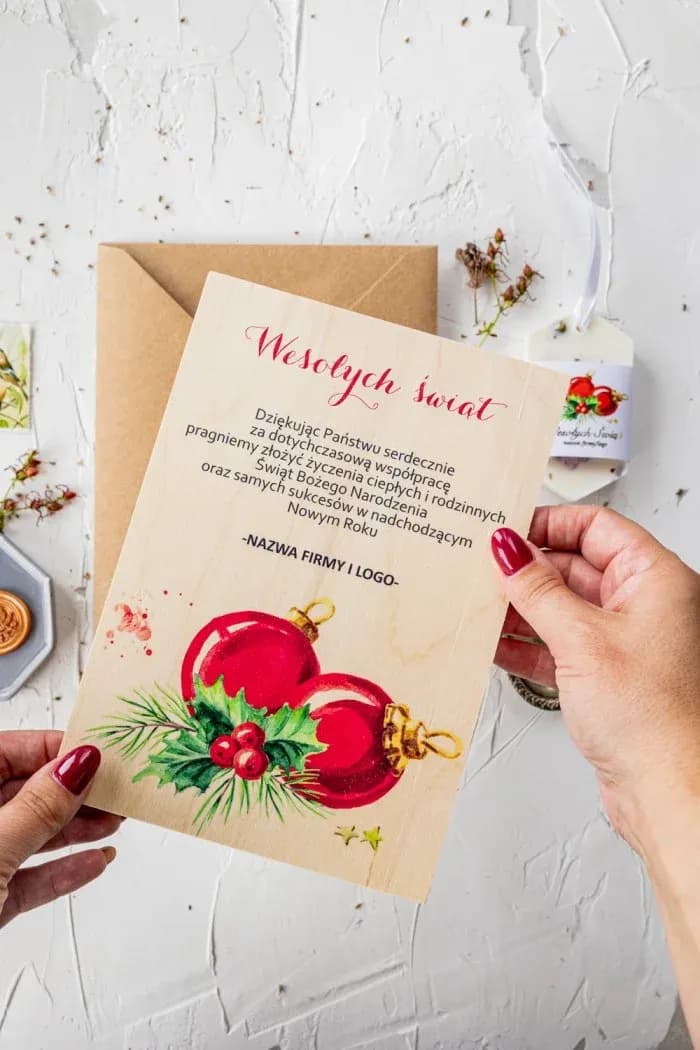 Carte de vœux bois entreprise boules rouges Carte de Noël en bois avec graphisme de boules rouges et genévrier, personnalisée avec logo d'entreprise.