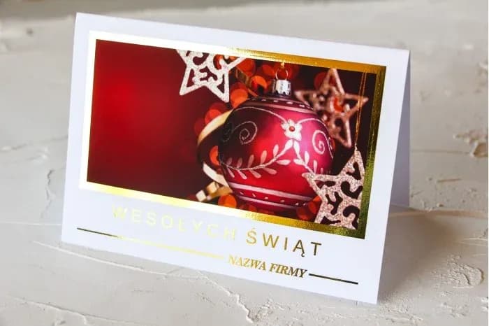 Carte de Noël de luxe avec dorure SZ2 Élégante carte de vœux entreprise avec boule de Noël rouge et accents dorés sur fond blanc.