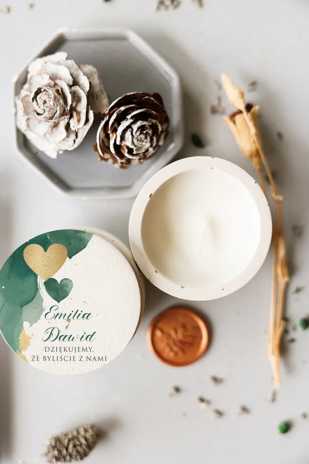 Personalized soy candle in a concrete-style container with a bottle green and gold heart label