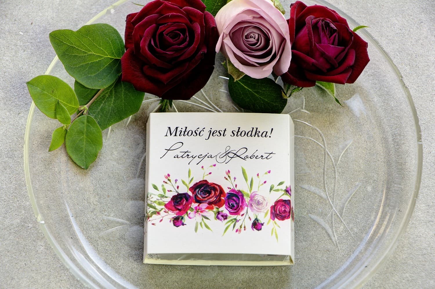 Gastgeschenk zur Hochzeit: Vollmilchschokolade, Banderole mit bordeauxroten Rosen und Feldgras