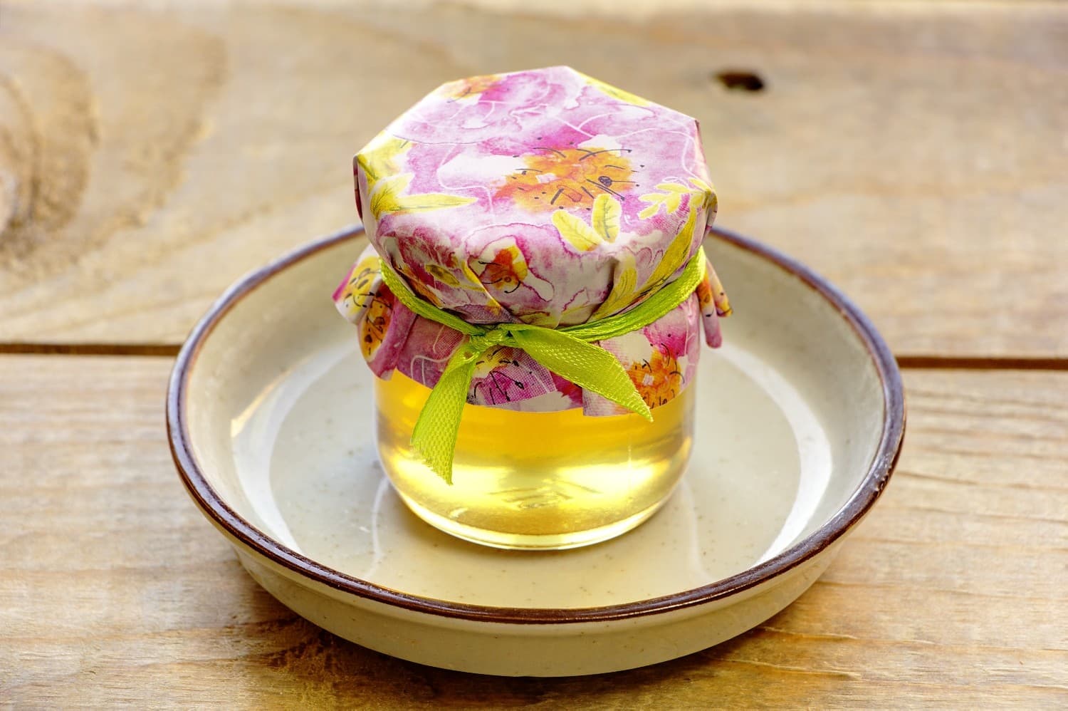 Süße Gastgeschenke für die Hochzeitsgäste in Form von kleinen Honiggläsern mit Blumenetikett.