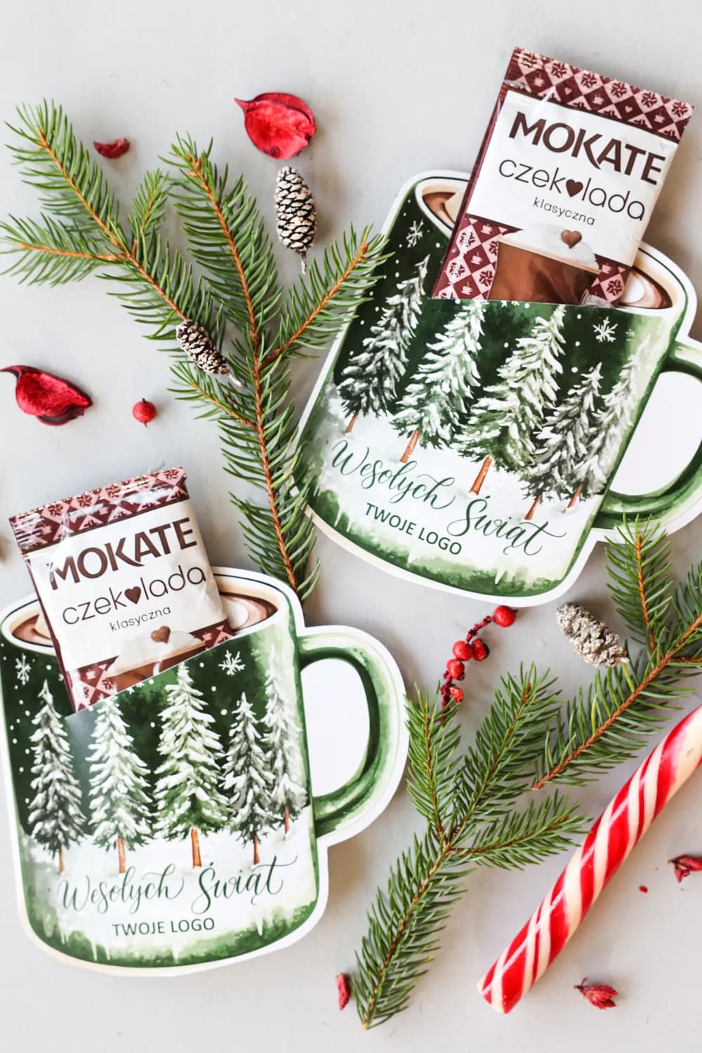 Creative Christmas arrangement with CZK4 promotional chocolate, candy cane, and snowy tree motif on a grey background.