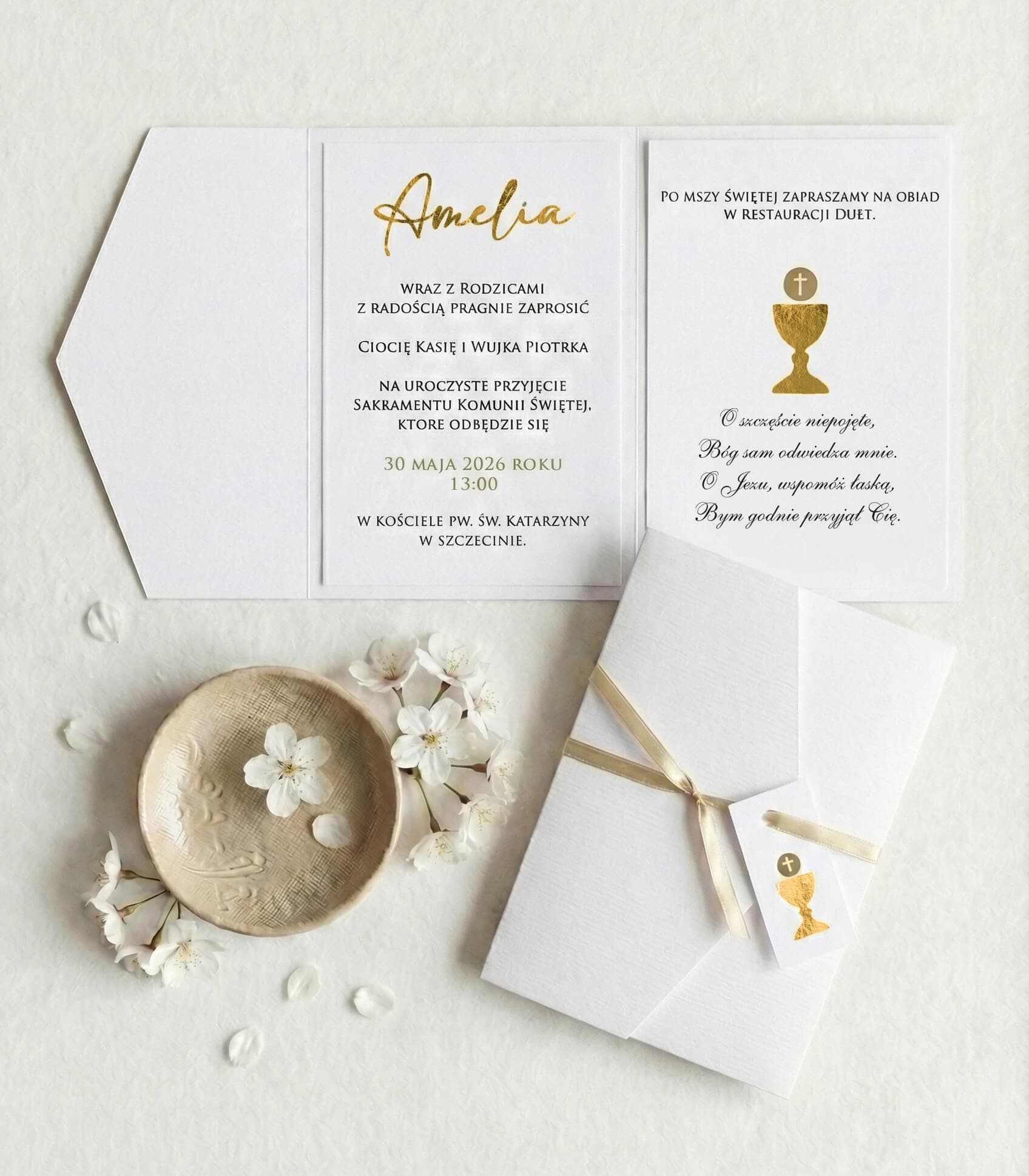 Elegante invitación blanca para comunión atada con un lazo de satén dorado y una etiqueta.