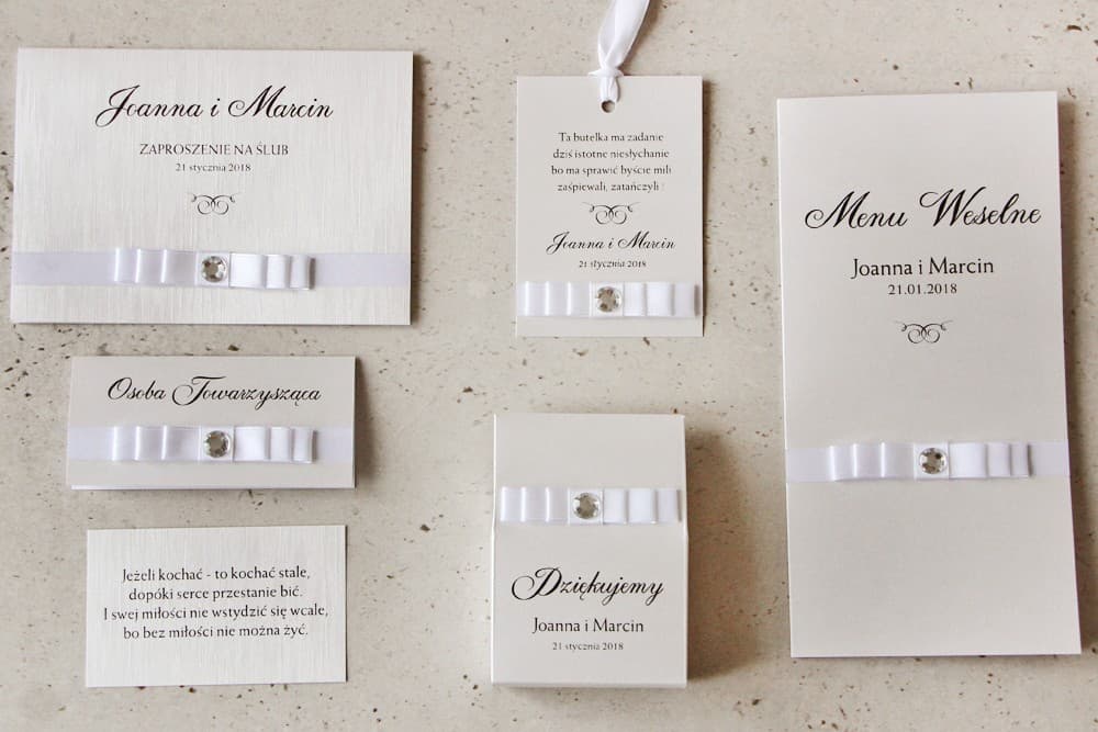 Zaproszenia ślubne z winietkami i menu kolekcja Amaretto Invitación de boda con accesorios - Amaretto nº 9 - Papel perlado con textura de lino, lazo blanco con circonita