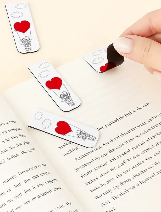 Composición que muestra recuerdos personalizados para invitados: marca-páginas magnéticos con tarjetas decorativas