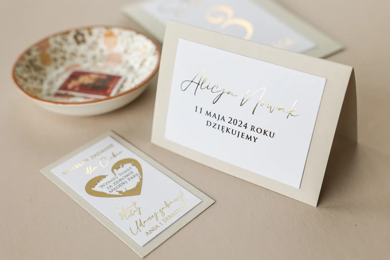 Marque-place de mariage beige et or Avril n°10 Marque-place de mariage beige élégant avec étiquette personnalisée et finitions dorées.