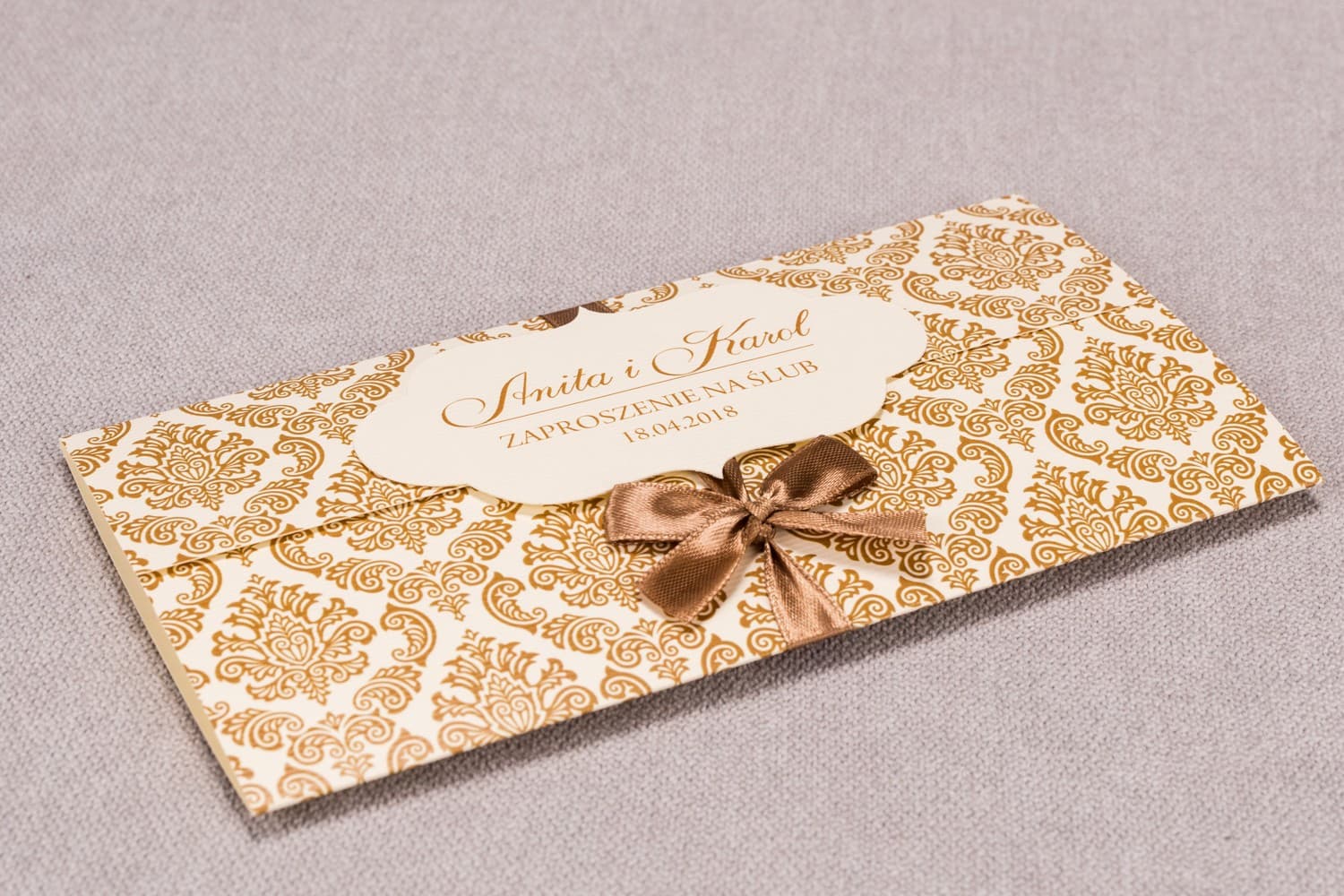 Eleganti partecipazioni nozze con motivo damasco e nastro - Madras n. 7 Classiche partecipazioni nuziali Madras n. 7 con fiocco marrone e ornamento Amelia Wedding