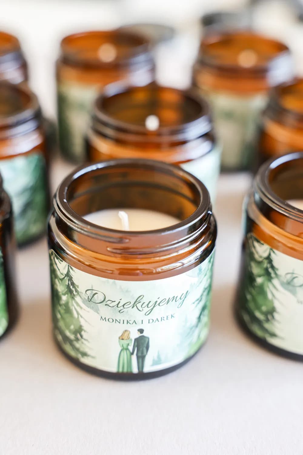Sojowa świeczka w brązowym słoiczku z zieloną etykietą przedstawiającą motyw lasu.
