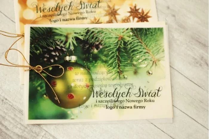 Tarjeta de Navidad con bola verde, papel perlado y cordón dorado, diseño elegante.