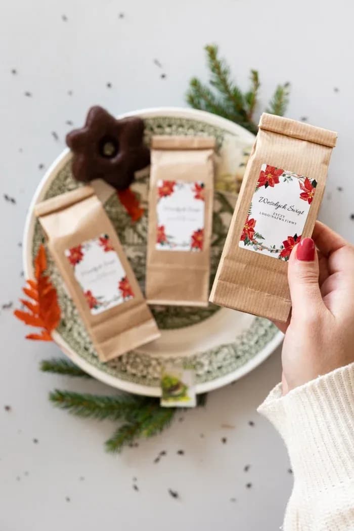 Tè in bustina kraft con etichetta che raffigura poinsettie rosse e rametti verdi
