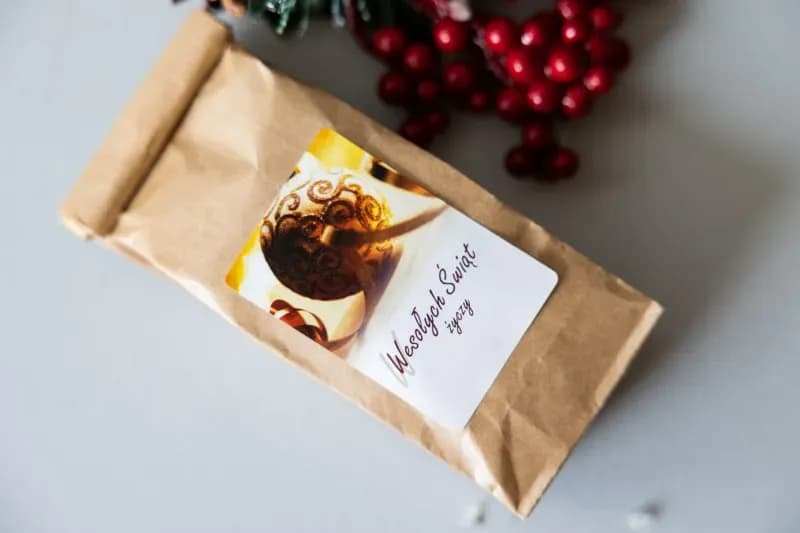 Omaggio con pallina dorata e logo personalizzato Dettaglio regalo aziendale natalizio – bustina con tè nero ed etichetta con logo cliente e grafica pallina dorata