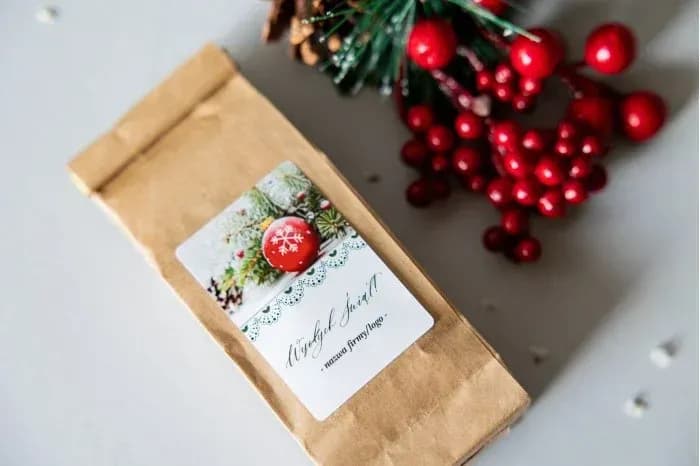 Tea in a kraft bag with a label featuring a red bauble with a snowflake and green needles