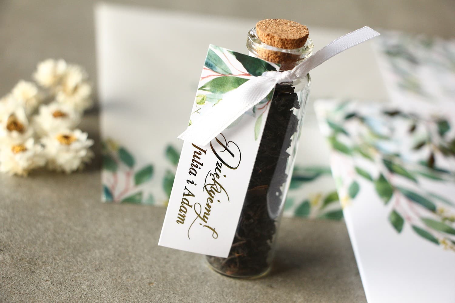 Gastgeschenke in Form von Teefläschchen. Anhänger mit Maiglöckchen und vergoldeten Elementen