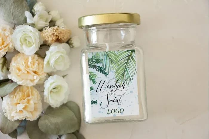 Vela de soja en frasco de vidrio transparente con etiqueta de acuarela de ramas verdes y tapa dorada