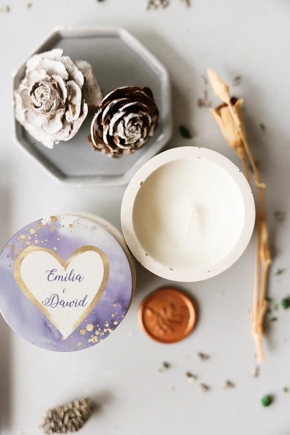 Primer plano de una vela de soja personalizada en recipiente de cemento con tapa decorada