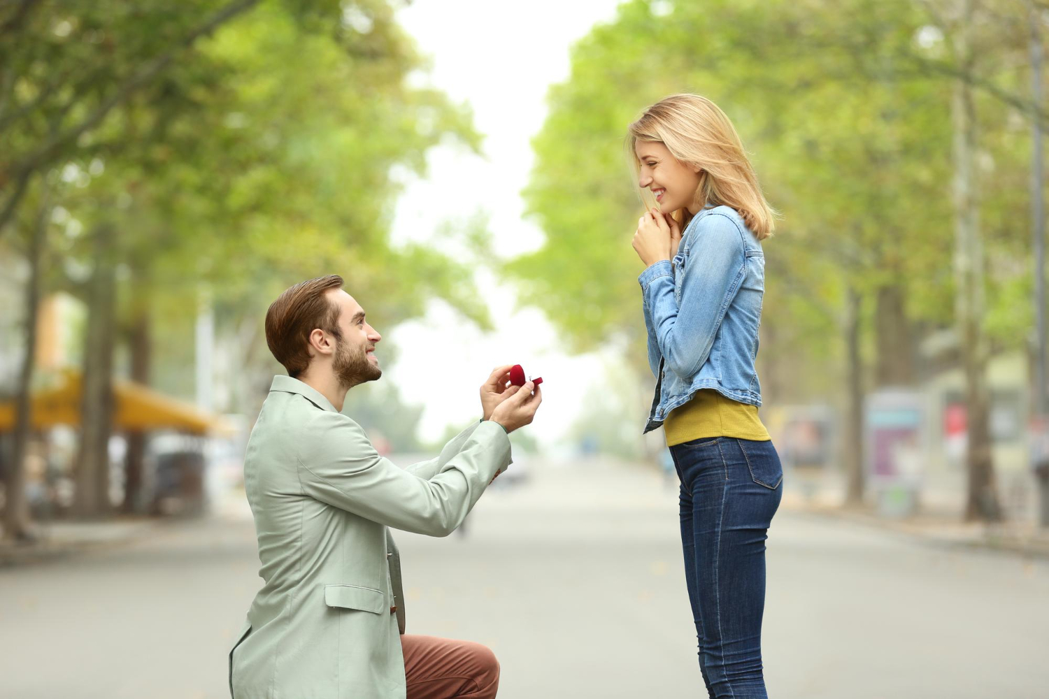 Zdjęcie młodego mężczyzny z pierścionkiem zaręczynowym oświadczającego się swojej ukochanej dziewczynie